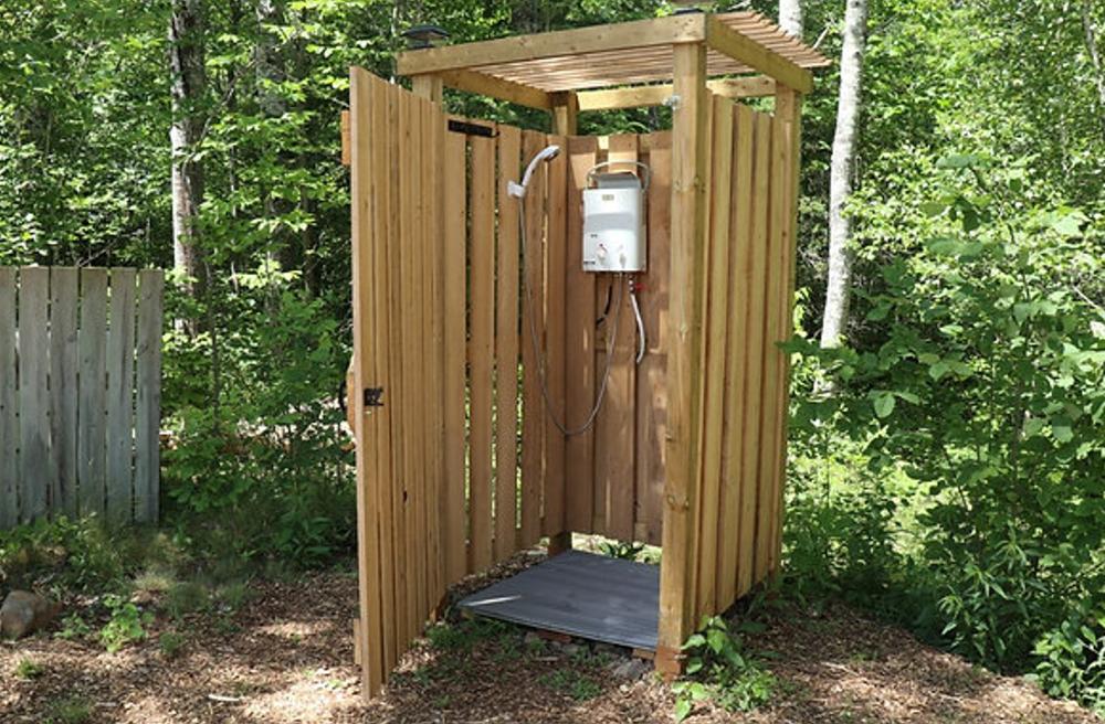 Private outdoor shower at forest glamping site in Nova Scotia
