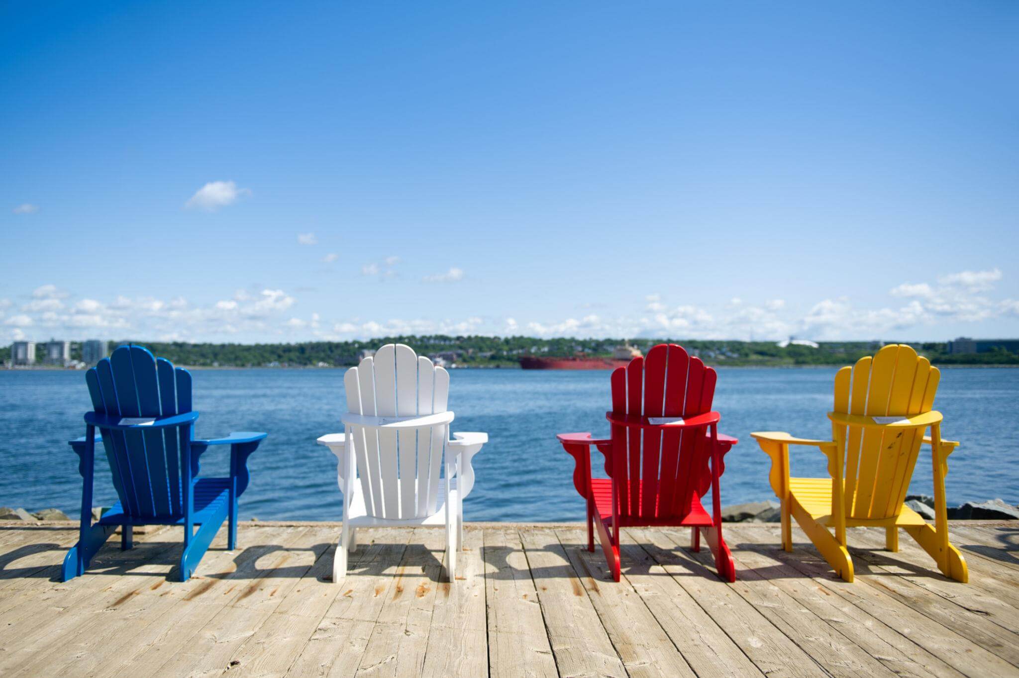 Bright Adirondack chairs overlooking Halifax Harbour along the waterfront boardwalk