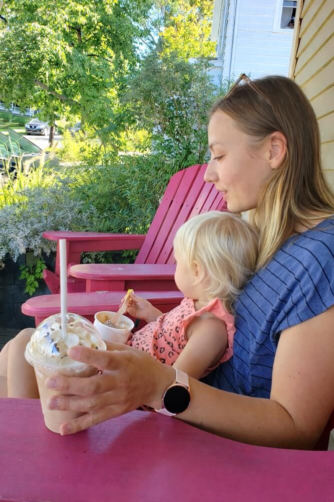 Parent and child enjoying ice cream on the porch at The Real Scoop in Wolfville, Nova Scotia